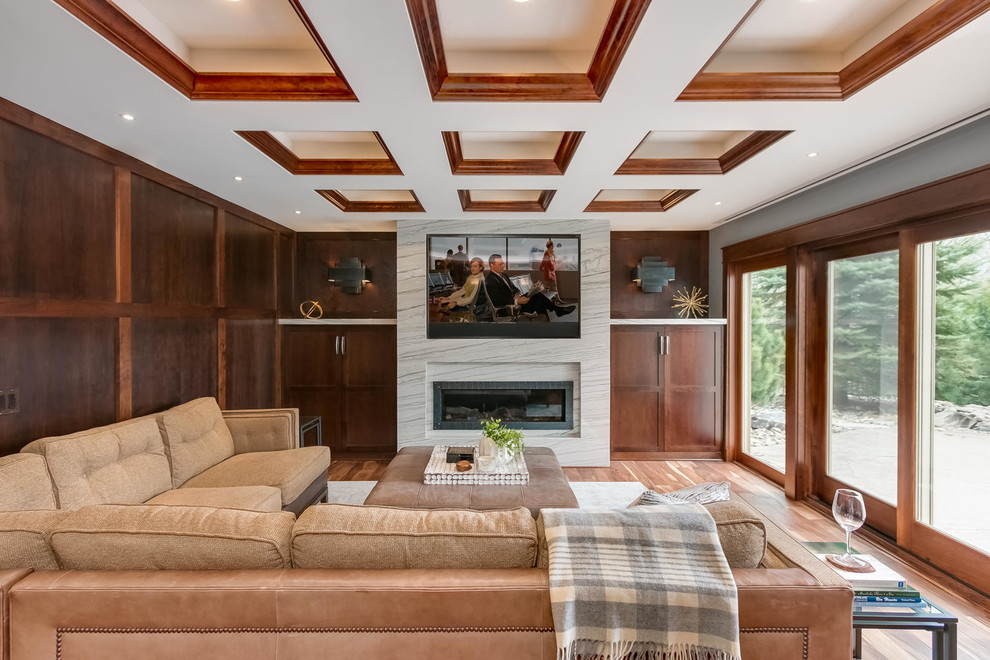 Example of a classic medium tone wood floor family room design in Minneapolis with brown walls and a ribbon fireplace