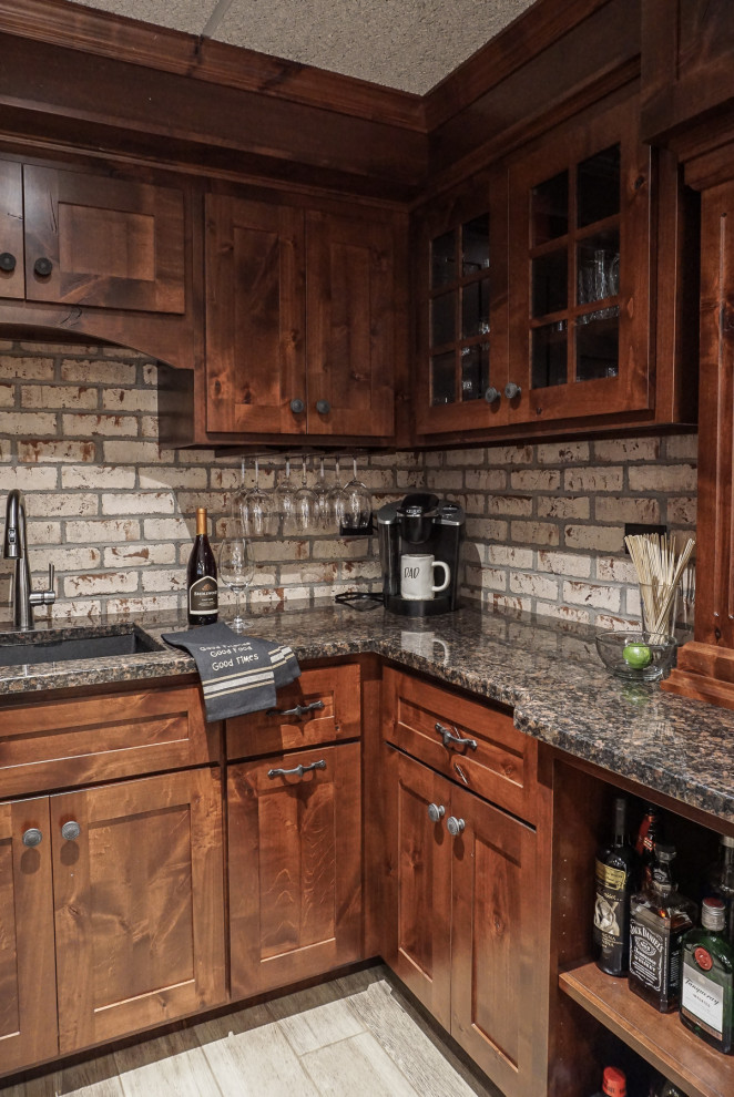 Exempel på en liten rustik källare ovan mark, med en hemmabar, vita väggar, ljust trägolv, en dubbelsidig öppen spis, en spiselkrans i tegelsten och grått golv