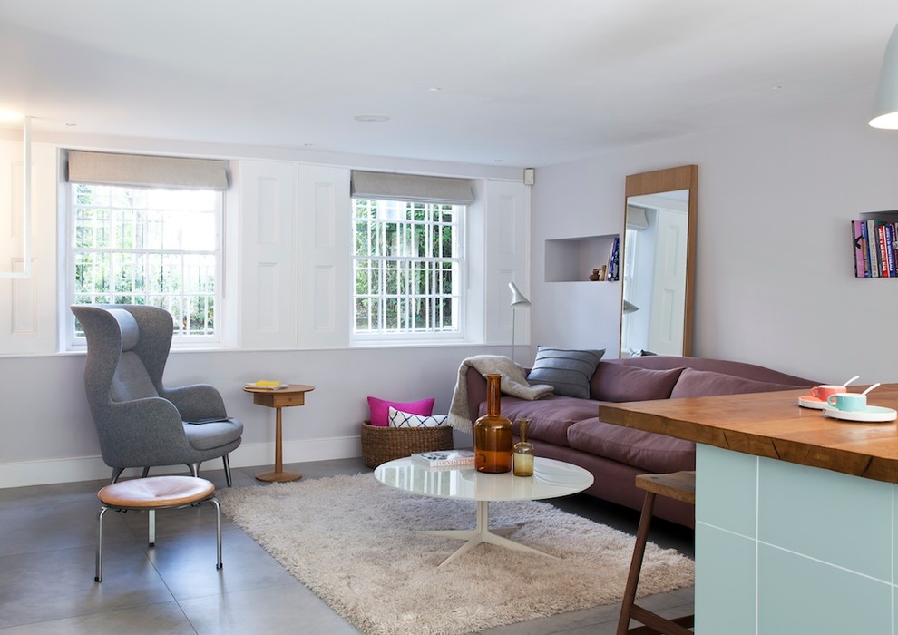 На фото: гостиная комната в современном стиле с белыми стенами и полом из керамической плитки без камина с