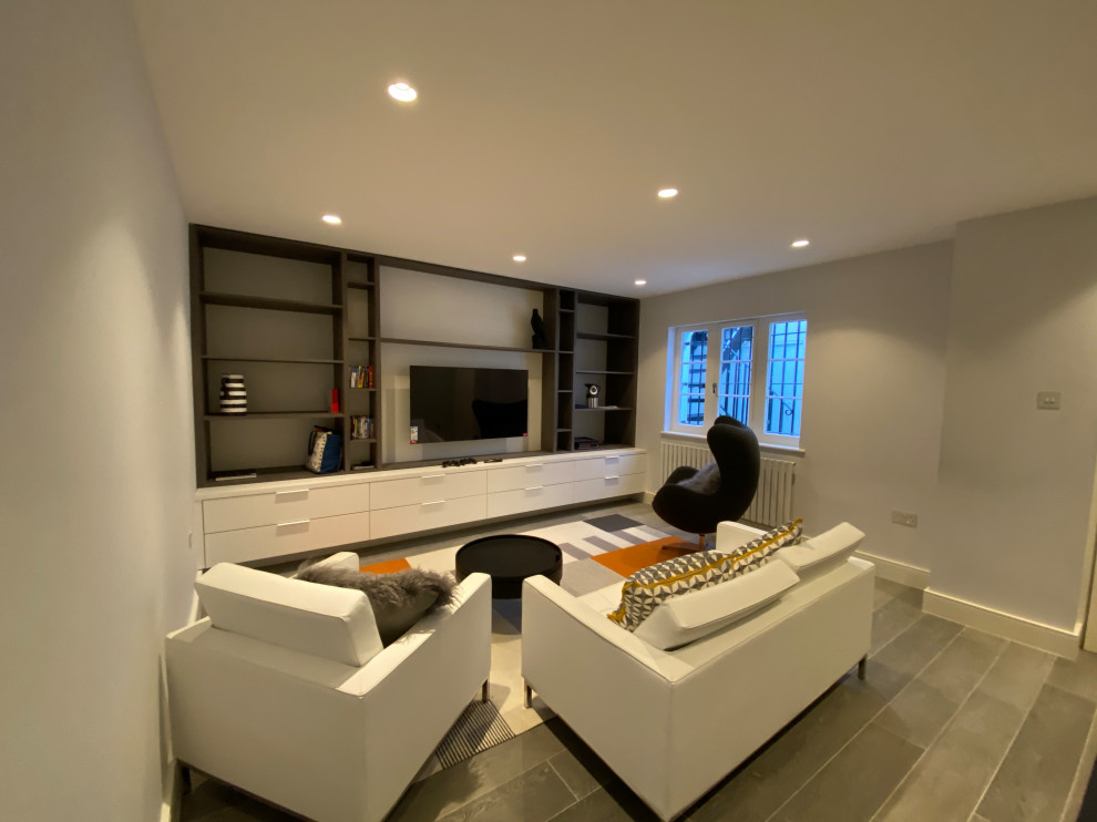 Large minimalist walk-out porcelain tile and gray floor basement photo in London with gray walls