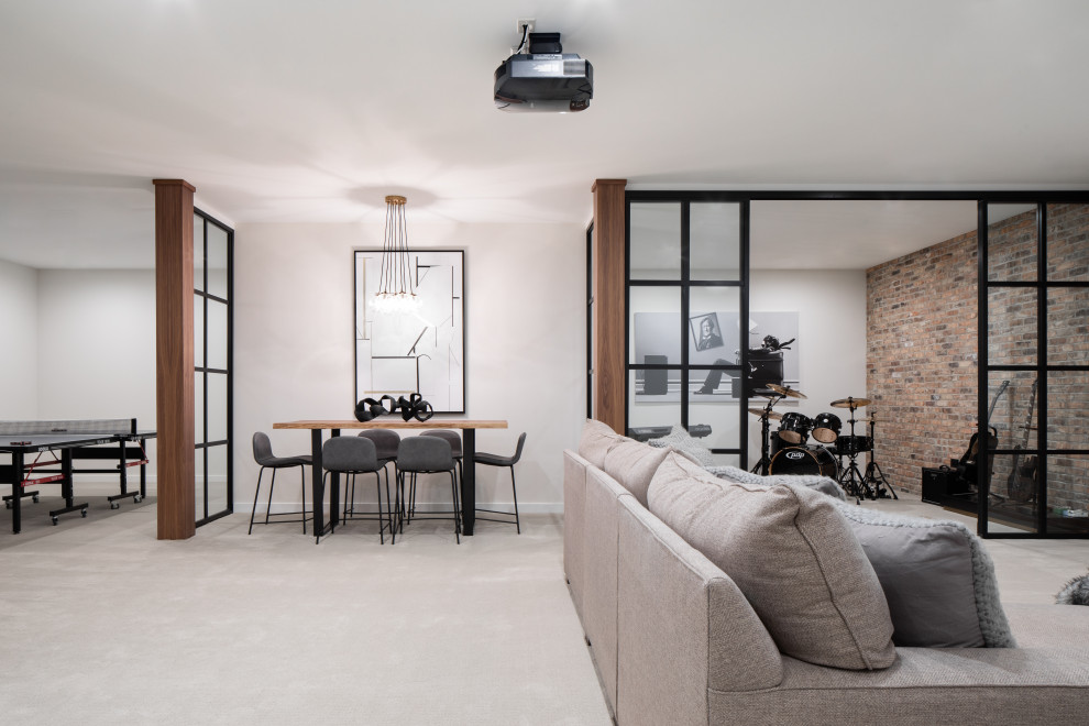 Photo of a contemporary basement in Chicago with white walls, carpet, grey floors and a feature wall.