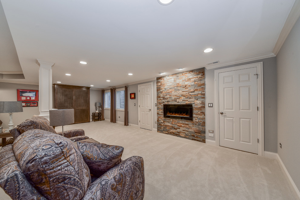 Inspiration for a large traditional fully buried basement in Chicago with grey walls, carpet, a ribbon fireplace and a stone fireplace surround.