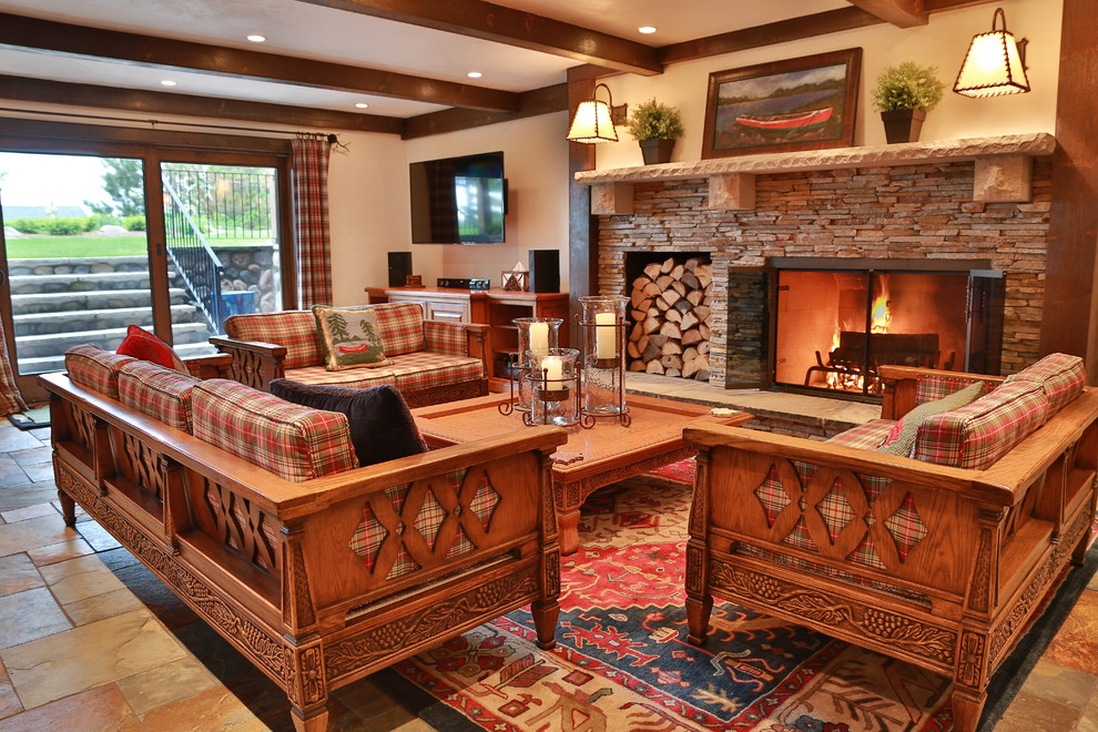 Large rustic walk-out basement in Other with beige walls, slate flooring, a standard fireplace and a stone fireplace surround.
