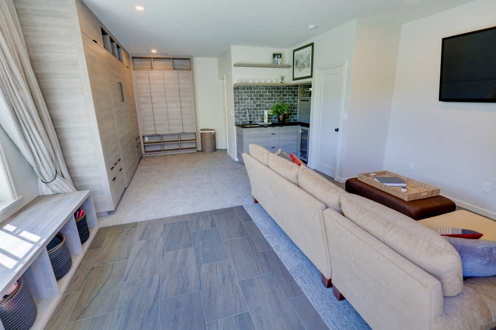 Medium sized contemporary walk-out basement in Seattle with white walls.