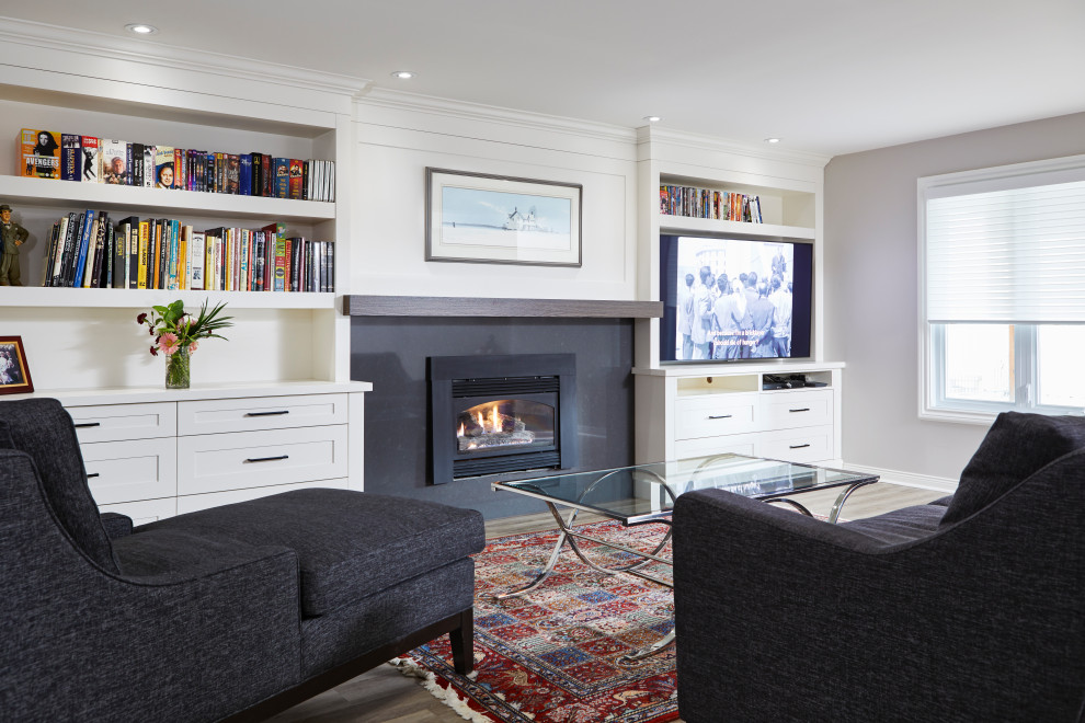Photo of a medium sized contemporary walk-out basement in Toronto with white walls, laminate floors, a standard fireplace, a stone fireplace surround and grey floors.