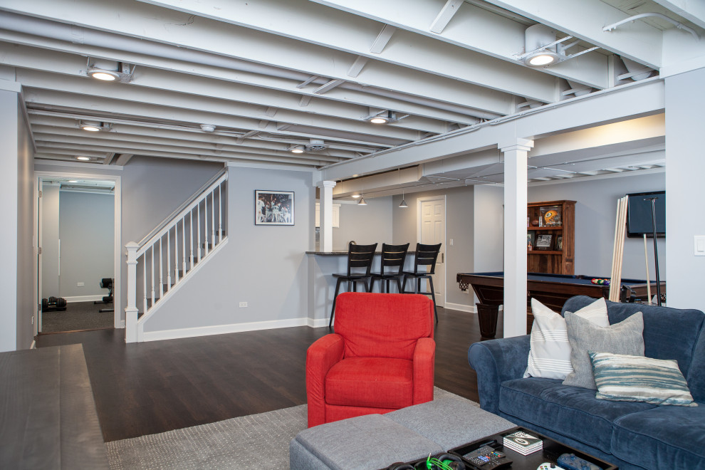 Inspiration for a large classic fully buried basement in Chicago with a game room, grey walls, vinyl flooring, brown floors and exposed beams.