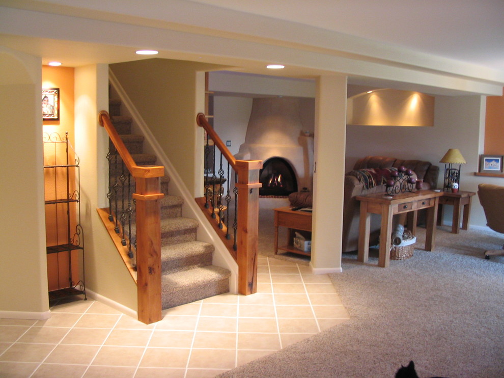 Aménagement d'un grand sous-sol classique avec un mur gris, moquette, un sol gris et une cheminée d'angle.