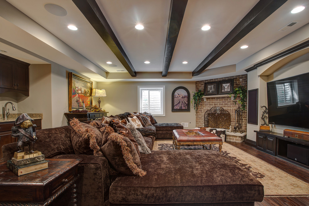 Photo of a large classic basement in Chicago with beige walls, dark hardwood flooring, a standard fireplace and a brick fireplace surround.