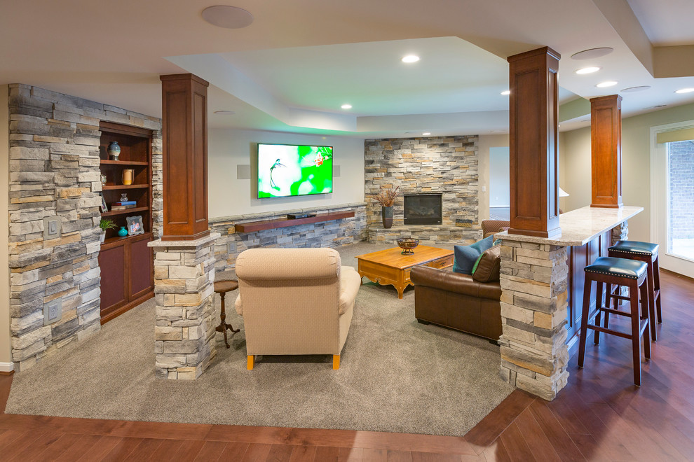 Basement - large traditional underground medium tone wood floor and brown floor basement idea in Cincinnati with white walls, a corner fireplace and a stone fireplace