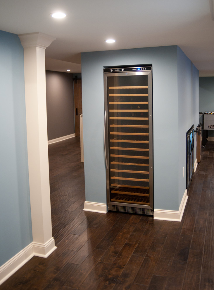 This is an example of a large traditional fully buried basement in Philadelphia with blue walls, dark hardwood flooring and brown floors.