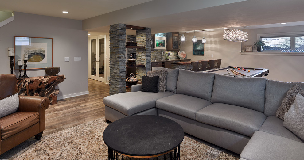 Basement - mid-sized transitional look-out vinyl floor and brown floor basement idea in Other with gray walls, a ribbon fireplace and a stone fireplace