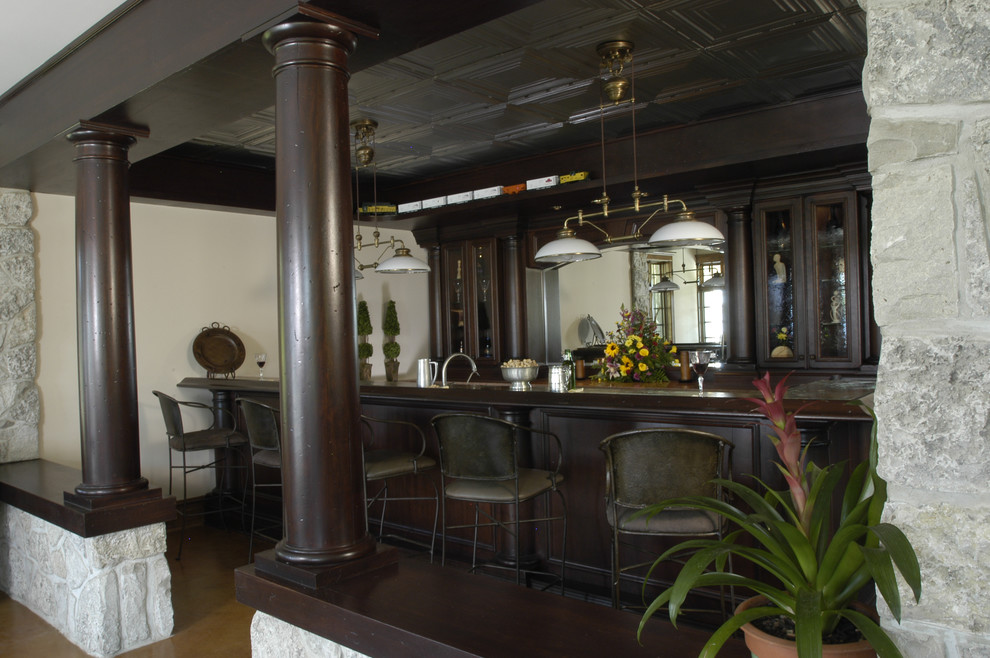 Ispirazione per un'ampia taverna rustica con sbocco, pareti beige e pavimento in cemento