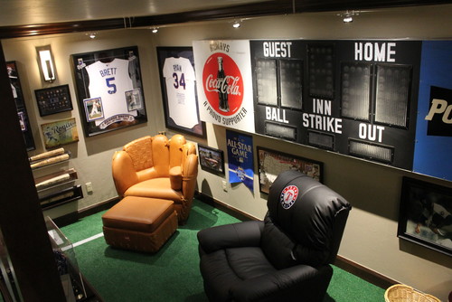 sports themed man cave with jerseys framed on the walls and a diy score board on the wall