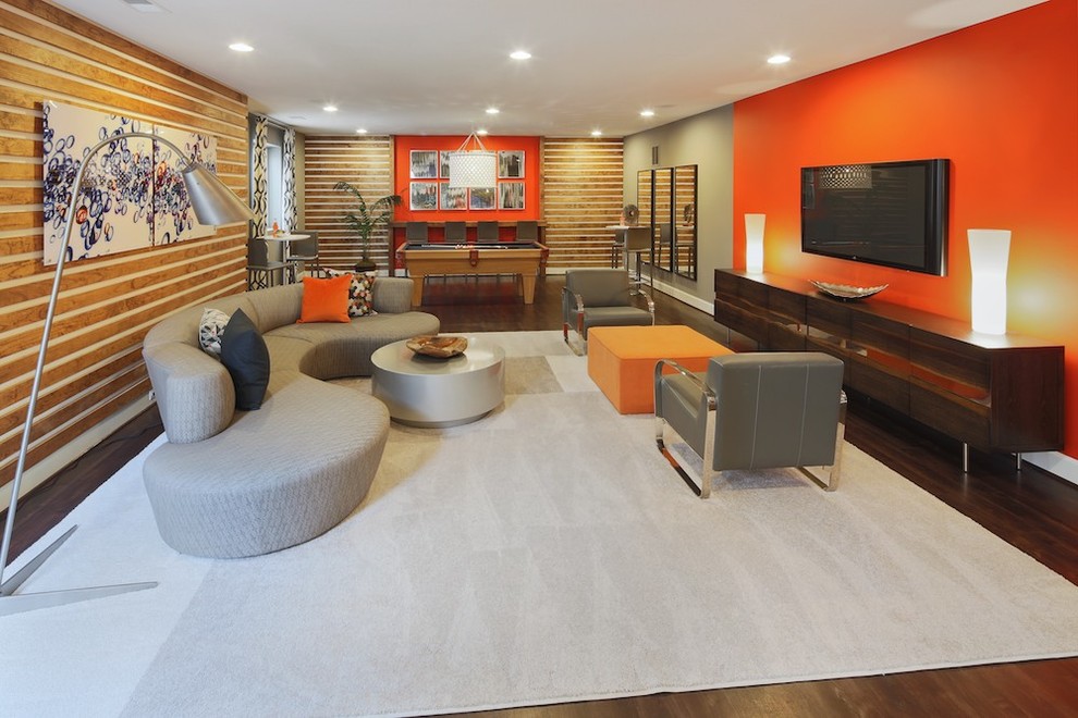 Idée de décoration pour un sous-sol tradition donnant sur l'extérieur avec parquet foncé et un mur orange.