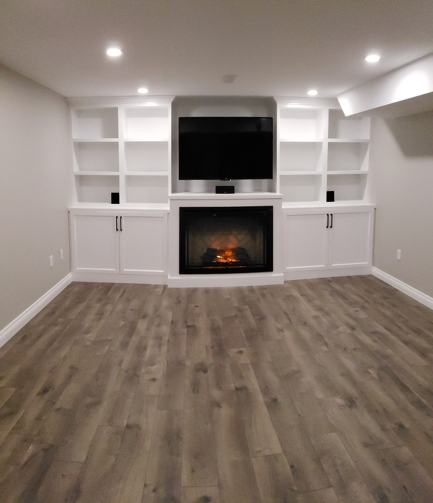 This is an example of a medium sized traditional look-out basement in Other with grey walls, laminate floors and grey floors.