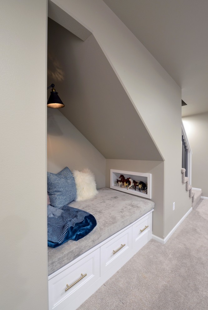 Cette image montre un grand sous-sol minimaliste semi-enterré avec un mur gris, moquette, une cheminée double-face, un manteau de cheminée en bois et un sol beige.