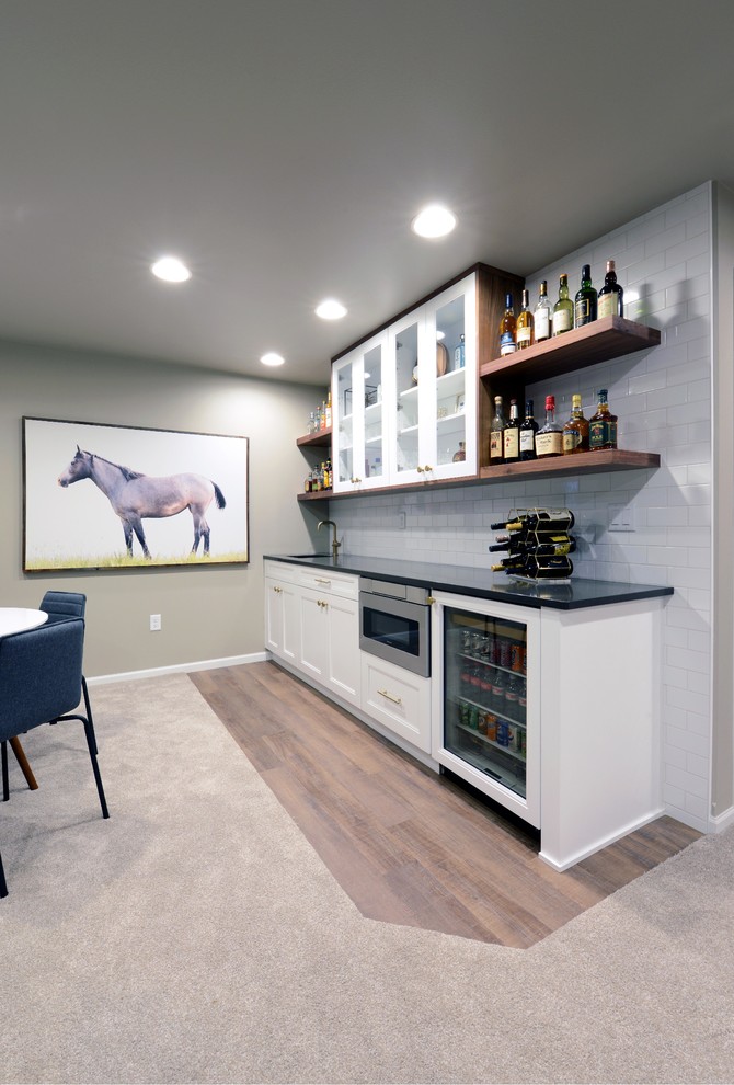 Large modern look-out basement in Other with grey walls, carpet, a two-sided fireplace, a wooden fireplace surround and beige floors.