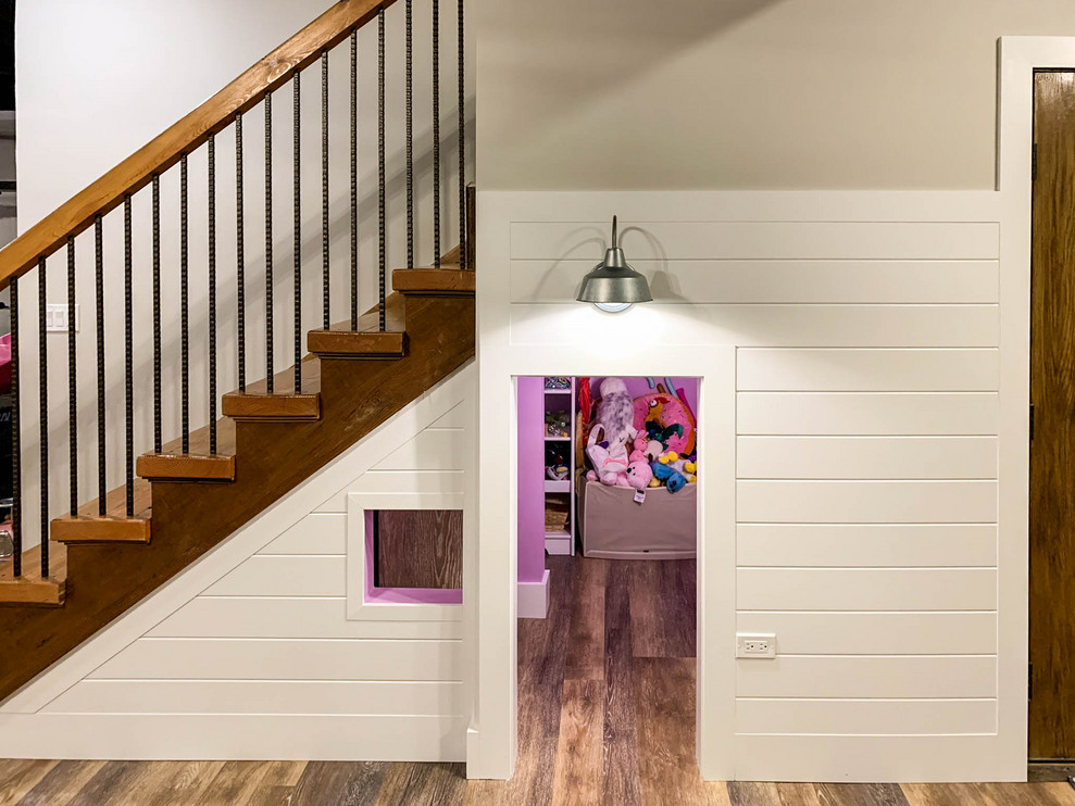 Modelo de sótano con puerta de estilo de casa de campo con paredes beige, suelo vinílico y suelo marrón