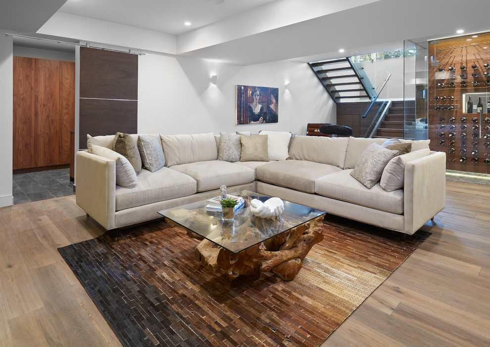 Modernes Wohnzimmer mit weißer Wandfarbe, hellem Holzboden und braunem Boden in Calgary