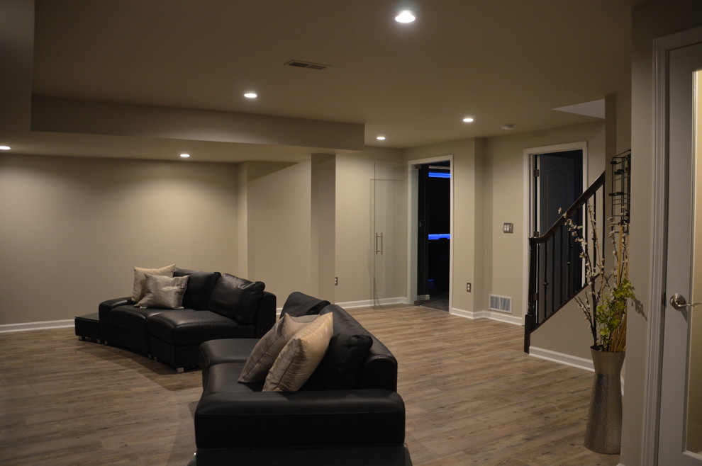 Example of a large minimalist underground vinyl floor and brown floor basement design in Detroit with beige walls and no fireplace