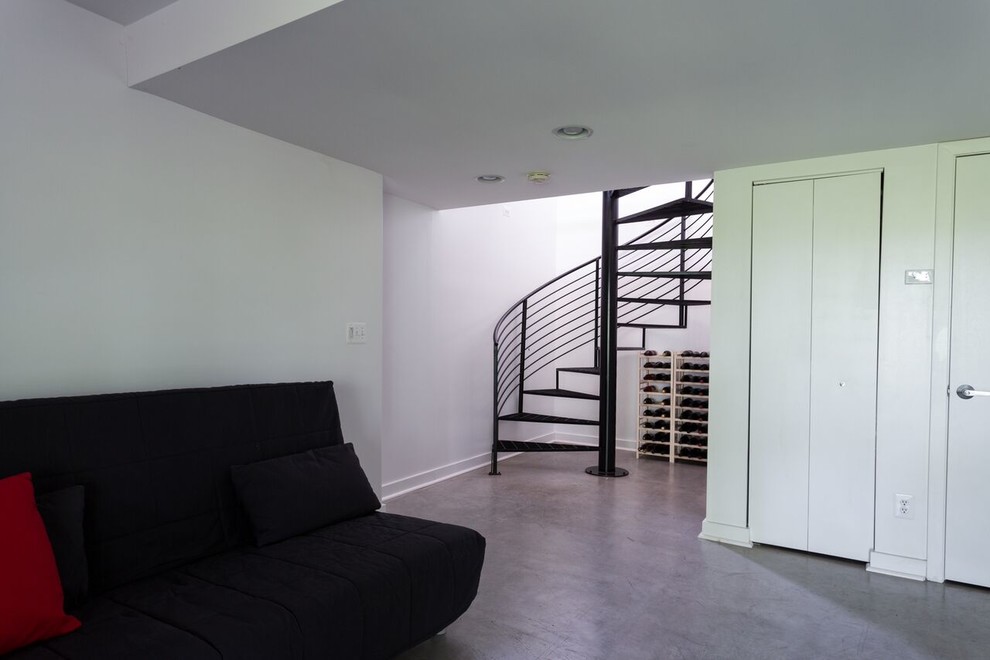 Foto på en mellanstor funkis källare utan fönster, med vita väggar, betonggolv och grått golv