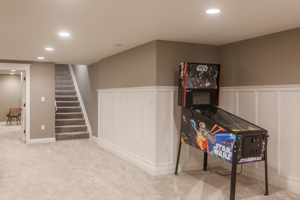 Large classic look-out basement in Cincinnati with a home cinema, beige walls, carpet, beige floors and wainscoting.
