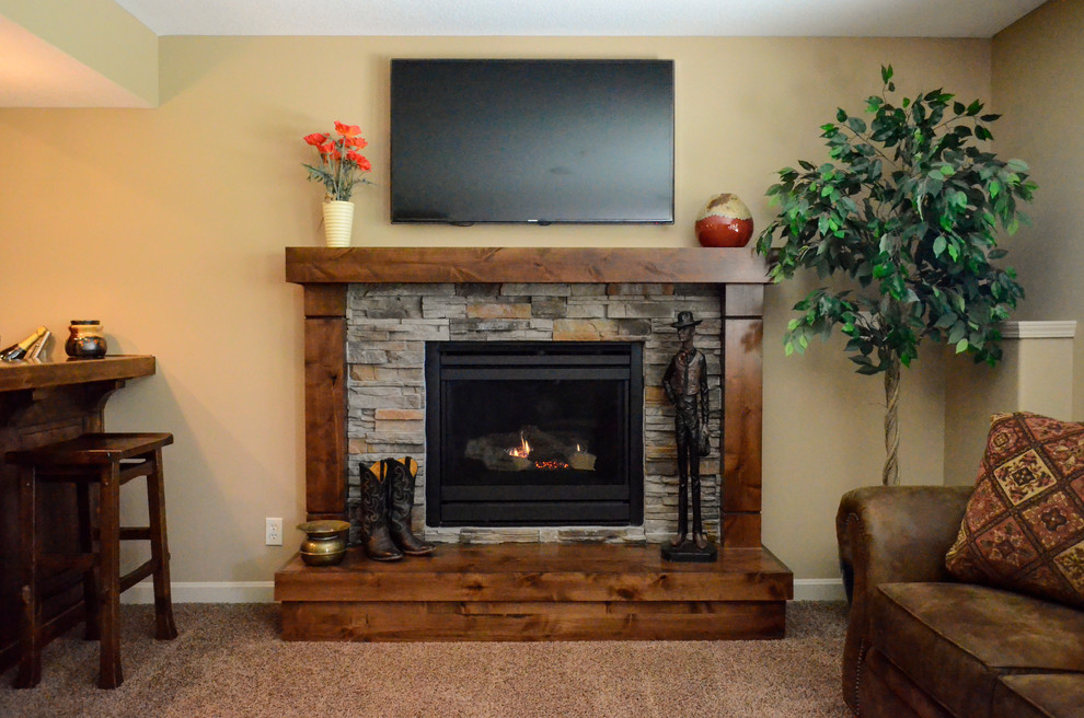 Inspiration for a mid-sized rustic walk-out carpeted basement remodel in Kansas City with beige walls, a standard fireplace and a stone fireplace
