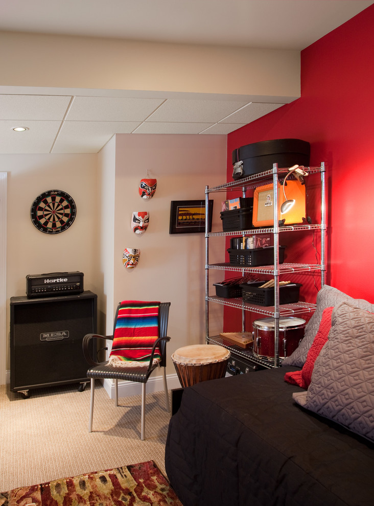 Cette image montre un sous-sol design donnant sur l'extérieur avec un mur rouge, moquette et un sol beige.