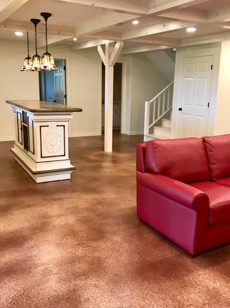 Example of a large mountain style walk-out concrete floor and brown floor basement design in Portland with white walls, a wood stove and a brick fireplace