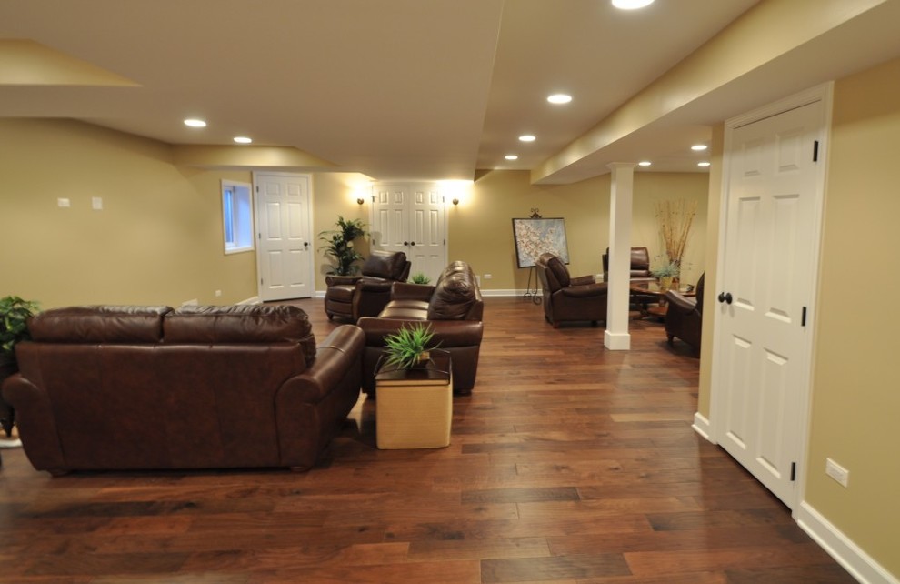 Photo of a large contemporary fully buried basement in Chicago with yellow walls, dark hardwood flooring and no fireplace.
