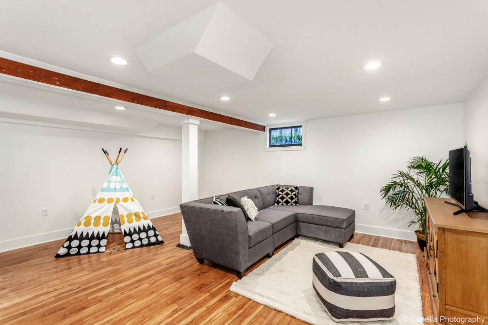 Medium sized classic basement in Portland with white walls and light hardwood flooring.