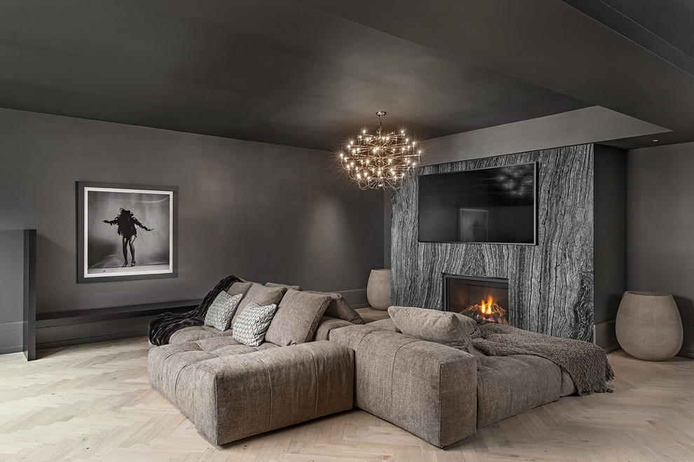 Diseño de sala de estar mediterránea con paredes negras, suelo de madera clara, todas las chimeneas, marco de chimenea de piedra y suelo beige
