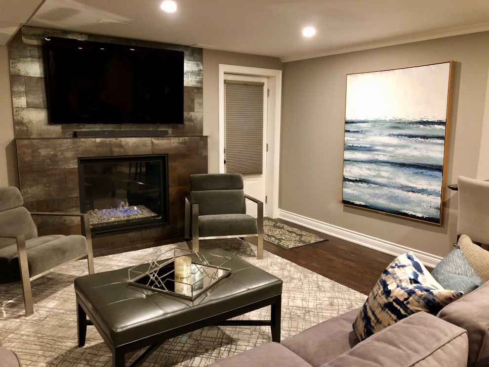 Design ideas for a medium sized contemporary walk-out basement in Toronto with grey walls, vinyl flooring, a standard fireplace, a tiled fireplace surround and brown floors.