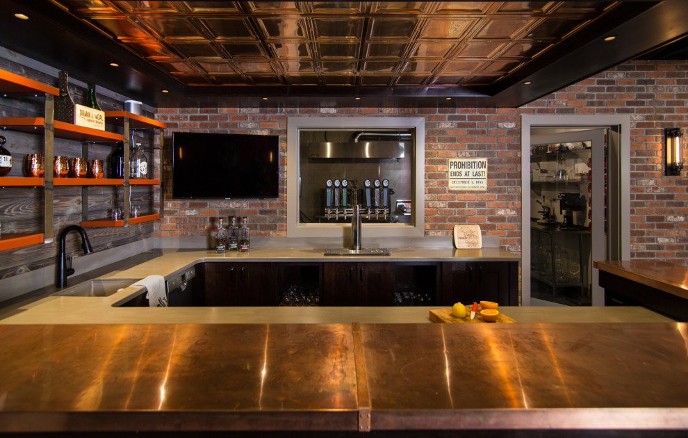 На фото: большой подвал в стиле лофт с домашним баром, бетонным полом и балками на потолке с