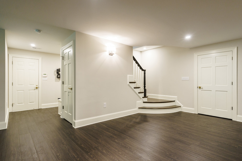 Imagen de sótano con puerta contemporáneo extra grande con paredes grises, suelo laminado y suelo marrón