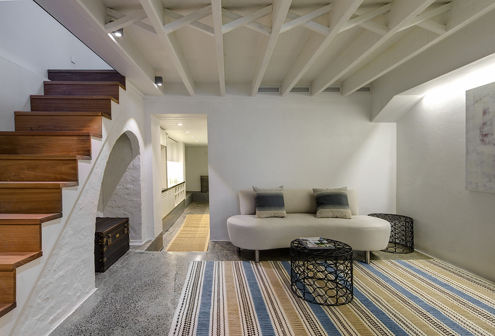Immagine di un soggiorno mediterraneo con pareti bianche, pavimento in cemento e pavimento grigio