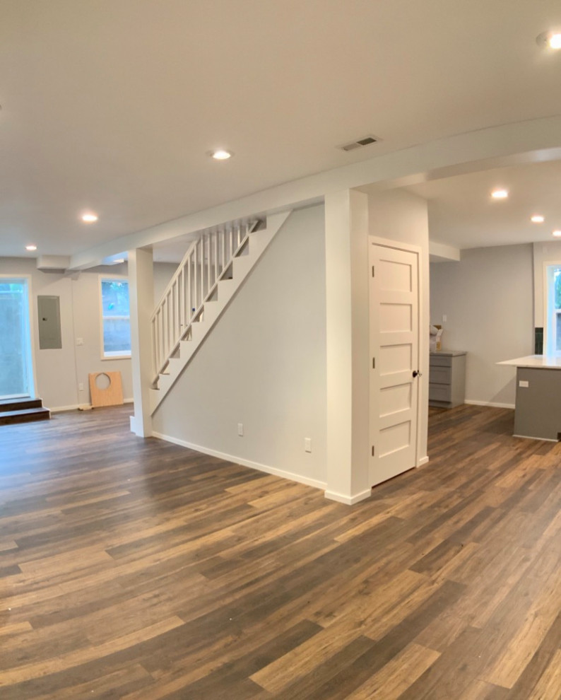 Design ideas for a traditional basement in Portland with grey walls, laminate floors and brown floors.