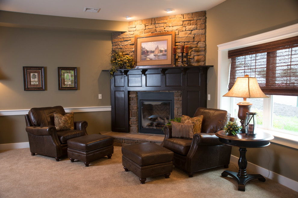 Photo of an expansive traditional basement in Other with green walls, carpet, a standard fireplace, a stone fireplace surround and beige floors.