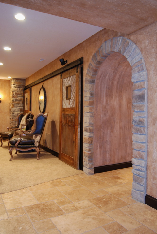 Large rustic fully buried basement in Kansas City with beige walls, travertine flooring and no fireplace.