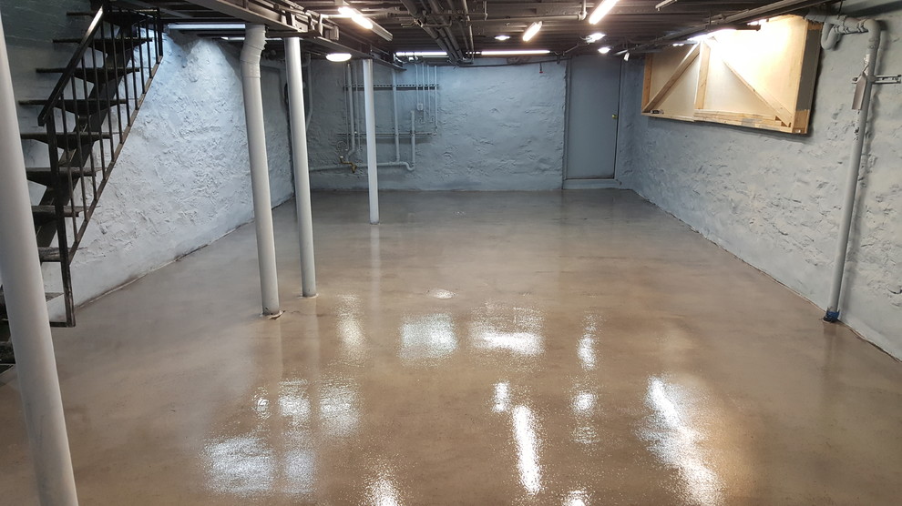Cette photo montre un sous-sol industriel de taille moyenne avec sol en béton ciré.