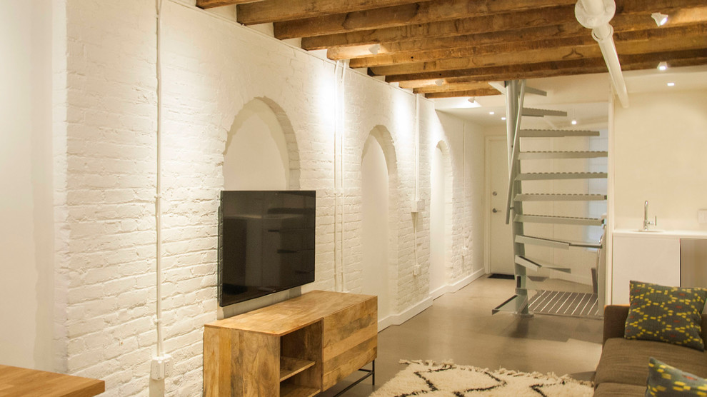 Modelo de sótano con puerta urbano de tamaño medio sin chimenea con paredes blancas y suelo de cemento