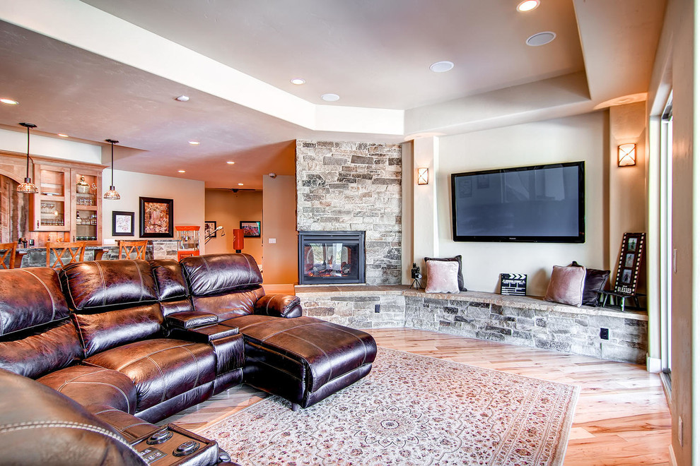 Example of a large classic walk-out light wood floor basement design in Denver with beige walls, a two-sided fireplace and a brick fireplace