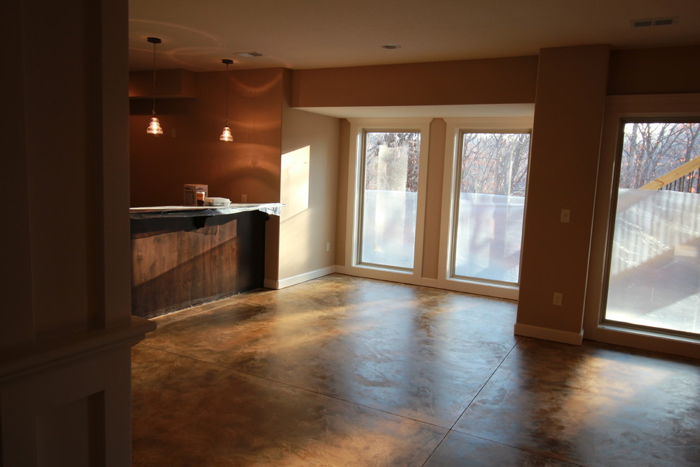 Cette photo montre un sous-sol tendance donnant sur l'extérieur avec un mur beige, sol en béton ciré et aucune cheminée.