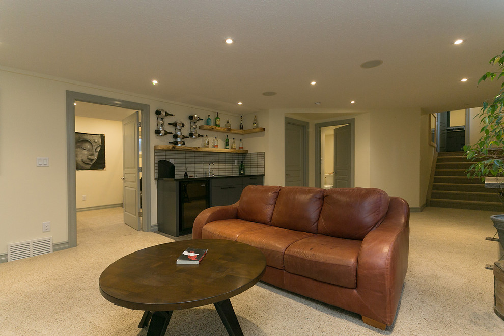 This is an example of a medium sized contemporary look-out basement with beige walls, carpet, a standard fireplace and beige floors.