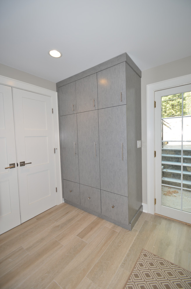 Ejemplo de sótano con puerta clásico renovado grande con paredes grises y suelo de baldosas de porcelana