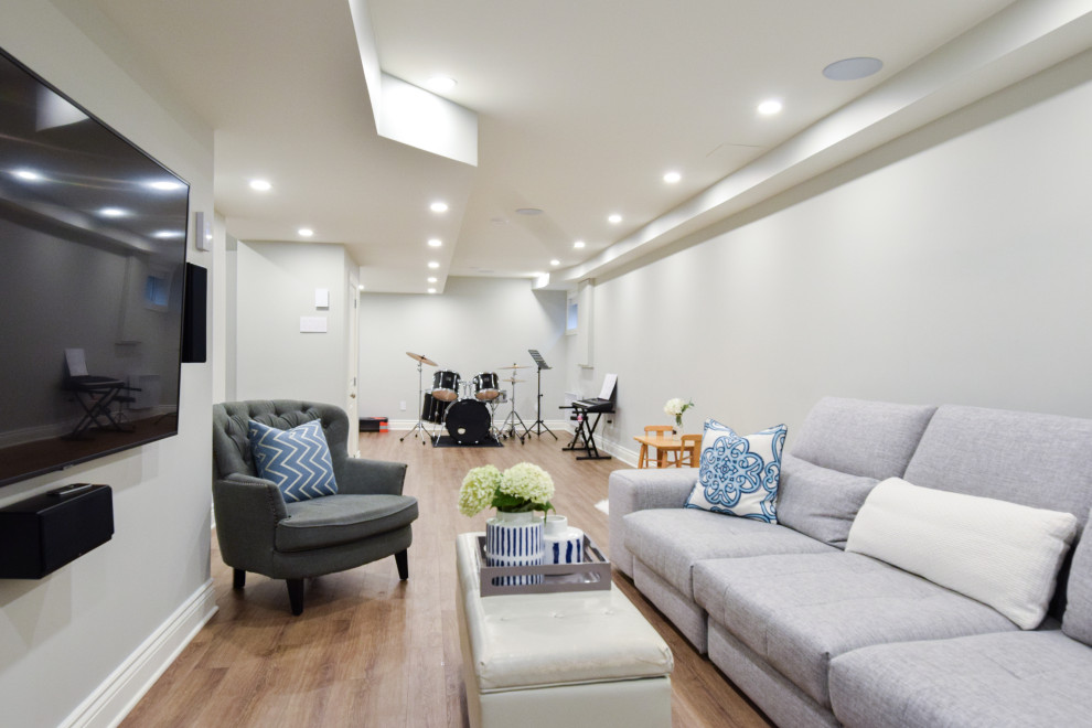 This is an example of a medium sized rural look-out basement in Montreal with a home cinema, grey walls, vinyl flooring and beige floors.