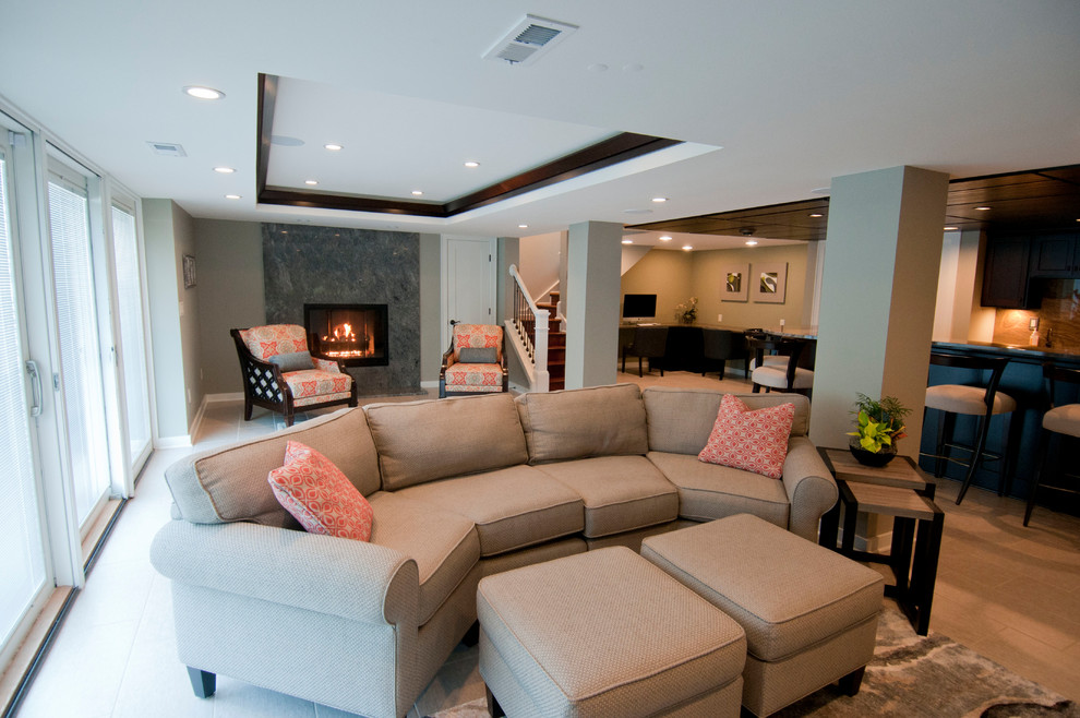 Photo of a large modern walk-out basement in Milwaukee with grey walls, vinyl flooring, a standard fireplace, a stone fireplace surround and grey floors.