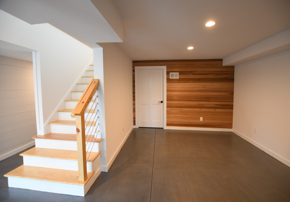 Ejemplo de sótano con puerta vintage grande con paredes blancas, suelo de cemento, suelo gris y panelado