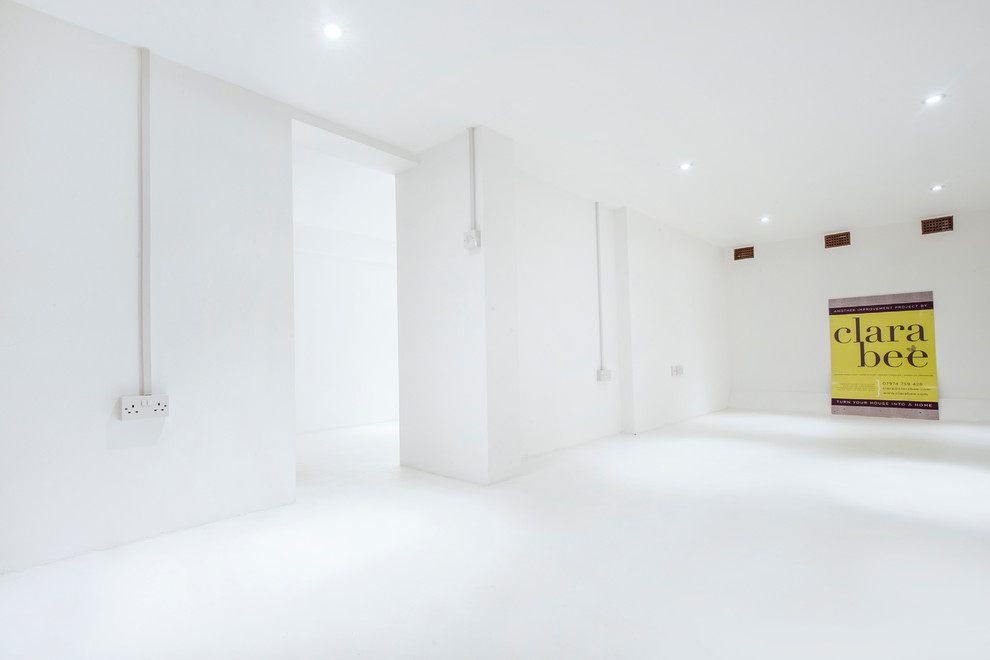 Источник вдохновения для домашнего уюта: большой подвал в стиле модернизм с белыми стенами и бетонным полом без камина