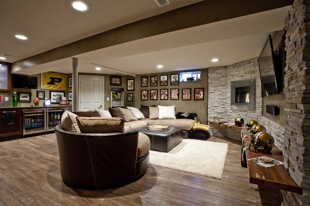 This is an example of a large classic fully buried basement in Other with a standard fireplace, a metal fireplace surround, brown walls, medium hardwood flooring and brown floors.